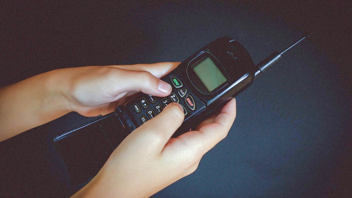 Celular antigo dos anos 90 simbolizando o ressurgimento das empresas daquela época por meio de investimentos em estrutura de IA
