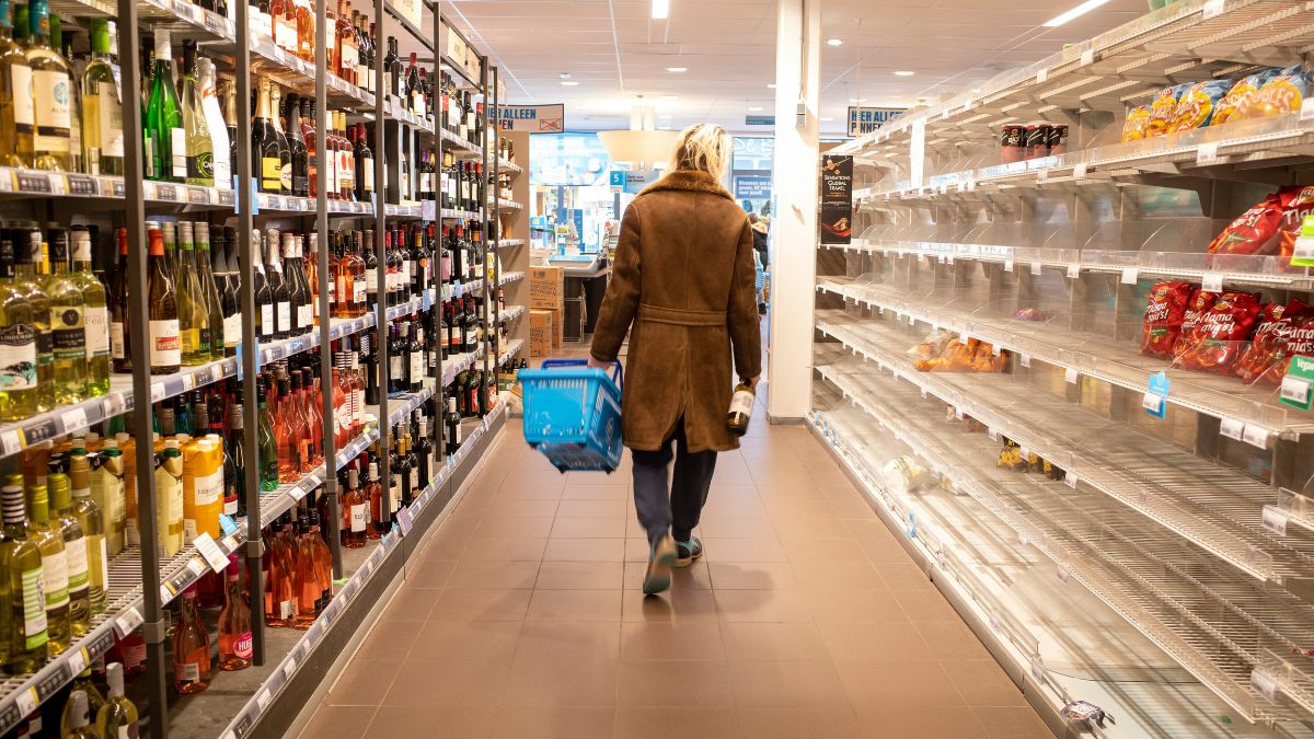 Prateleiras de supermercado abastecidas com produtos alimentícios, ilustrando o foco do consumo no cenário de juros atuais.