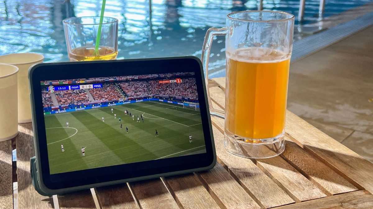 Tablet mostrando jogo de futebol ao lado de um copo de cerveja, para ilustrar o bom momento do mercado, com o aumento do consumo de cerveja na Copa do Mundo