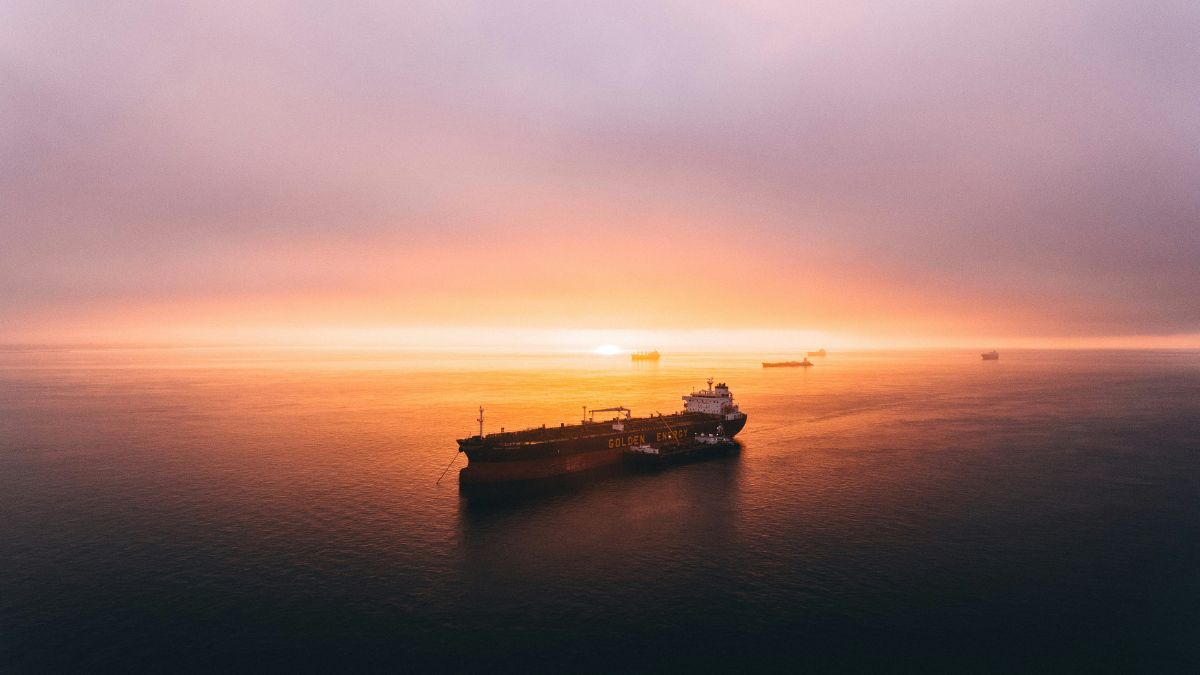 Navio petroleiro em mar aberto ao pôr do sol, simbolizando a exportação de petróleo refinado da China, que alivia mercados na Ásia