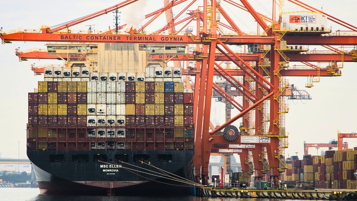 Navio cargueiro carregando contêineres em um porto, ilustrando o impacto do veto europeu sobre as exportações brasileiras de carne