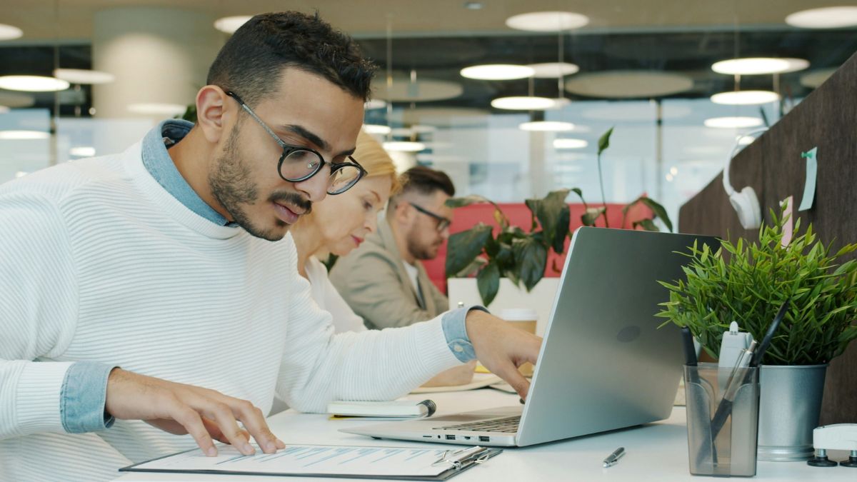 Profissional de tecnologia trabalhando em escritório corporativo moderno, analisando dados de inteligência artificial em notebook para avaliar o uso de GPU as a service.
