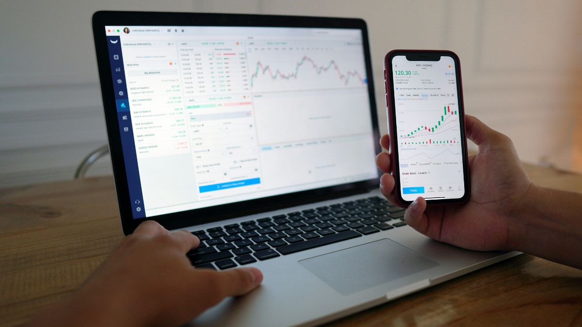 Investidor acompanhando o mercado financeiro pelo notebook e celular, na expectativa da Super quarta do Copom
