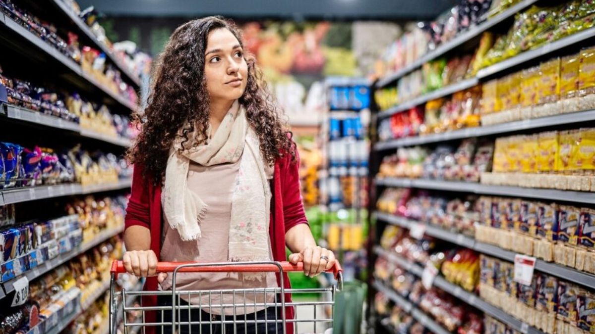 Consumidor analisando preços nas gôndolas de um supermercado em São Paulo, ilustrando a aceleração do Índice de Preços ao Consumidor (IPC-S).