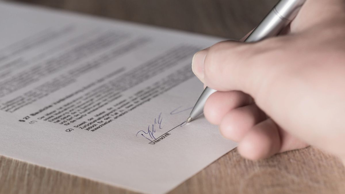Mão assinando contrato de aluguel, simbolizando que o Índice FipeZAP de Locação Residencial supera a inflação