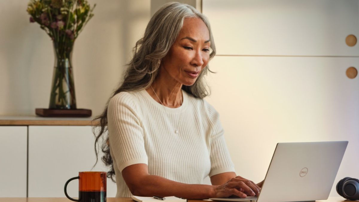 Mulher em escritório mexendo em laptop para ilustrar o investimento da Microsoft na capacitação de brasileiros.