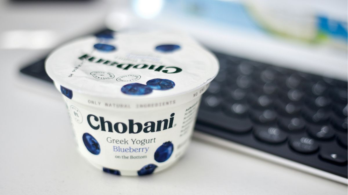 Embalagem do yogurte Chobani sobre uma mesa de trabalho, representando o avanço do mercado de alimentos ricos em proteínas no Brasil