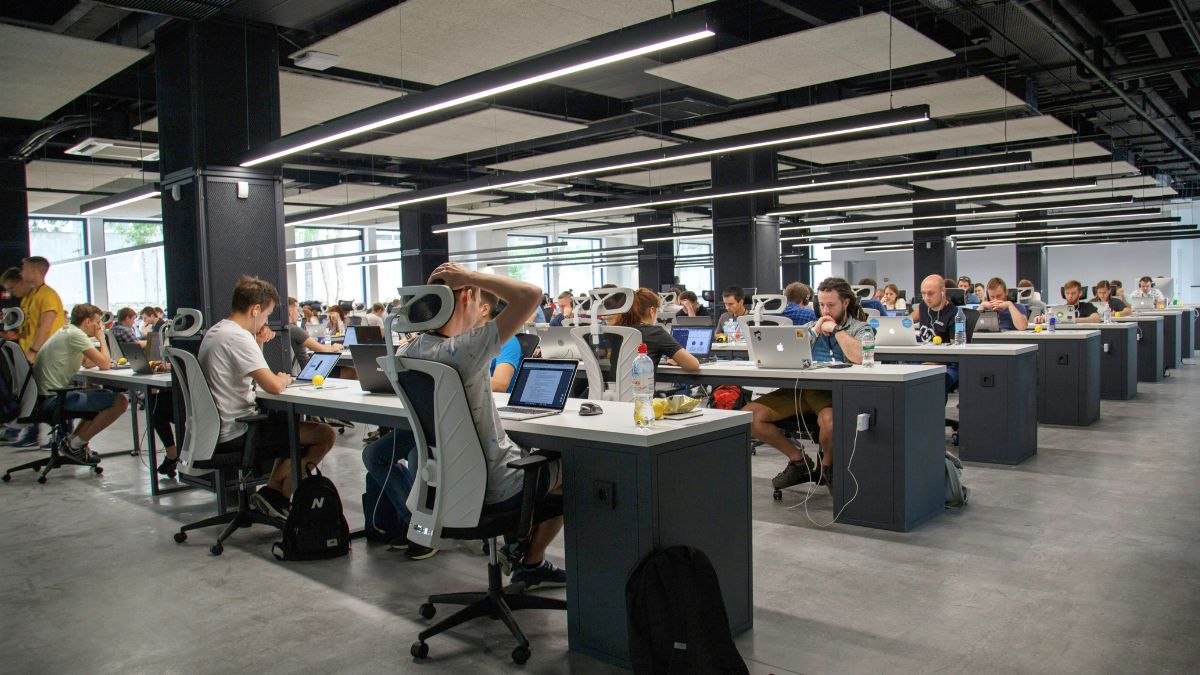 Ambiente empresarial, com pessoas trabalhando nos computadores simbolizando a compra do Cursor pela SpaceX