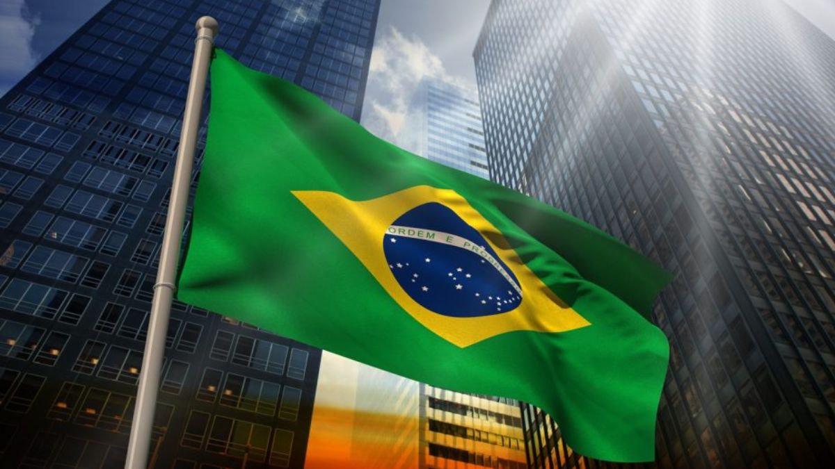 Bandeira do Brasil entre dois prédios executivos, para simbolizar que a sustentabilidade das contas externas do País enfrenta novo déficit