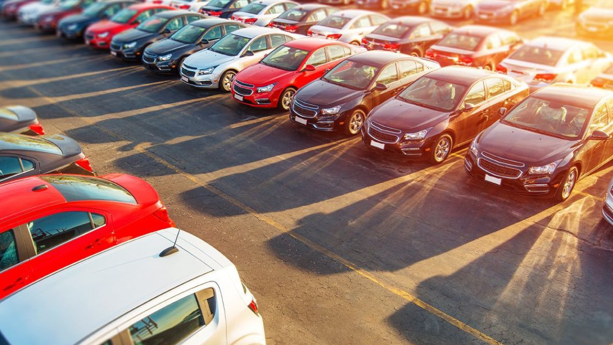 Fileiras de veículos zero quilômetro estacionados no pátio de uma concessionária para ilustrar o avanço na venda de carros novos