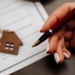 Chave de imóvel sobre contrato, indicando que o IGP-M subiu em outubro, pressionando reajustes de contratos no mercado imobiliário