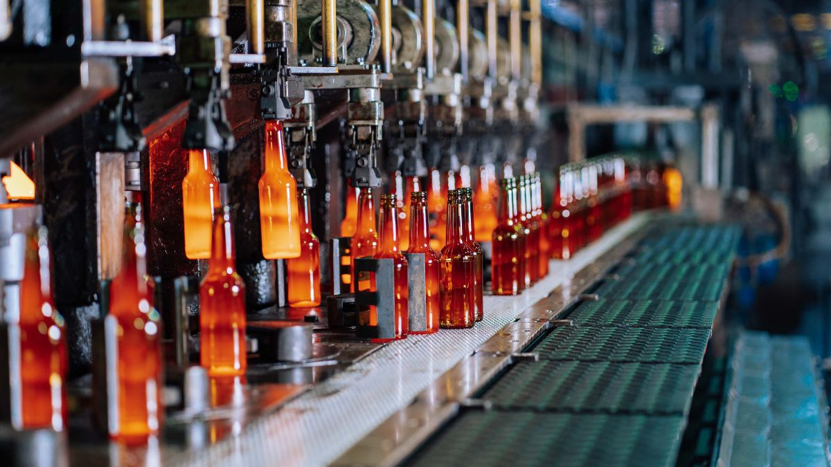 Linha de produção de bebidas, simbolizando que o Imposto Seletivo reúne governo e indústria em prol de desestimular o consumo de itens nocivos à saúde