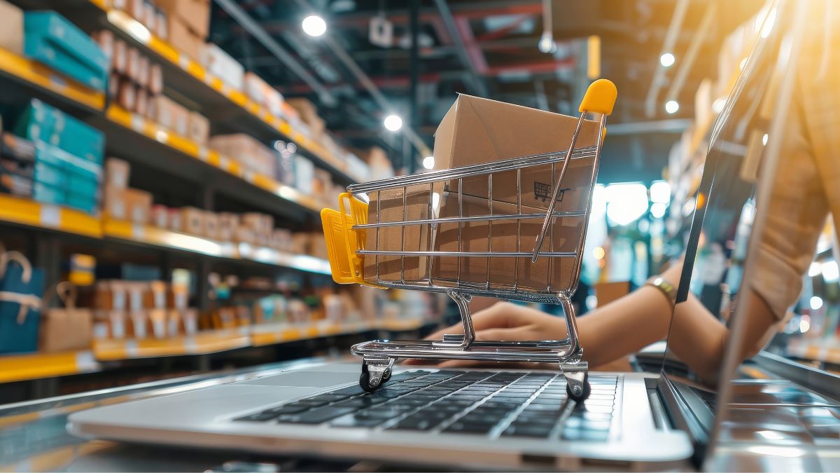 Mini carrinho de compras sobre computador, representando compras pelo e-commerce, simbolizando que os juros altos e a inadimplência das famílias freiam o varejo neste fim de ano