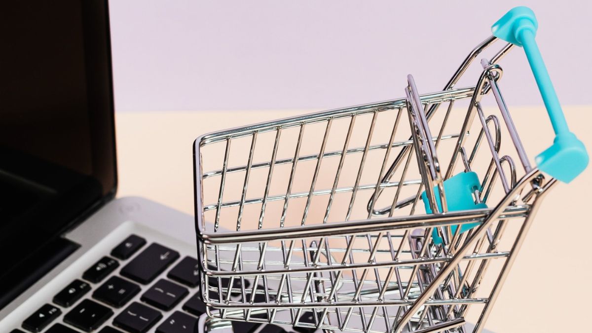 Mini carrinho de compras sobre teclado de computador, simbolizando que a Magalu e a Shopee fecharam parceria estratégica