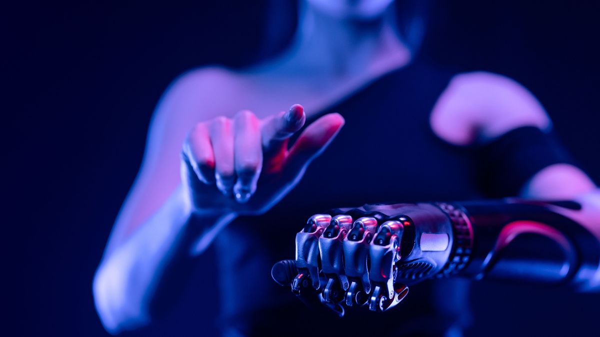 Humana utilizando braço robótico, para simbolizar que a Meta testa robôs em seus data centers e reacende debate sobre empregos na era da IA