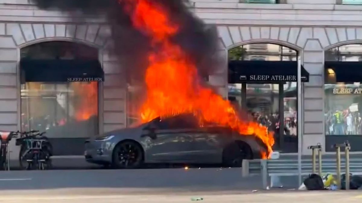 Carro em chamas, simbolizando que a onda de protestos na UE impacta o mercado brasileiro
