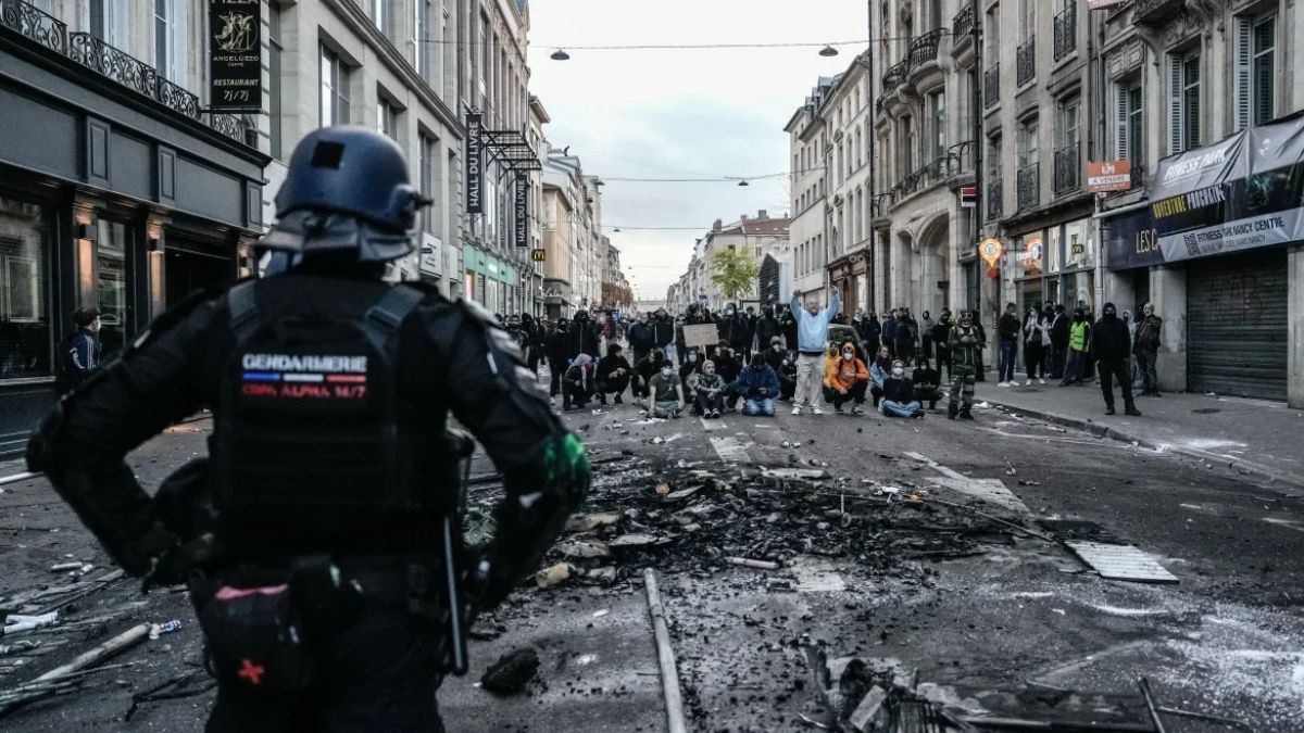 Rua na França destruída por protestos, simbolizando como a crise na França pode atingir o mercado financeiro do Brasil