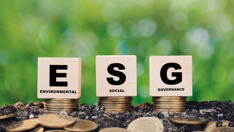 Iniciais ESG sobre moedas e folhas, simbolizando que as regras globais exigem auditoria rigorosa, impactando no custo de capital das empresas