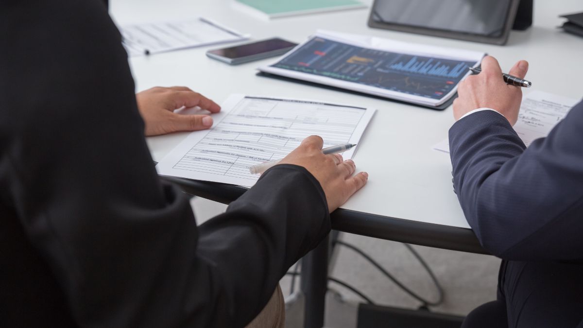 Mesa com executivos discutindo metas e cálculos, para simbolizar que o setor de Serviços do Brasil registrou oscilação negativa