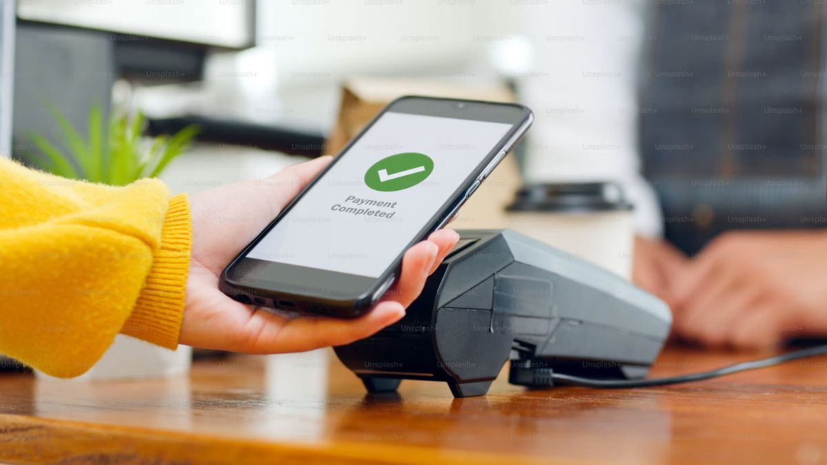 Celular pro aproximação pagando compra, simbolizando como o split payment afeta o fluxo de caixa das empresas